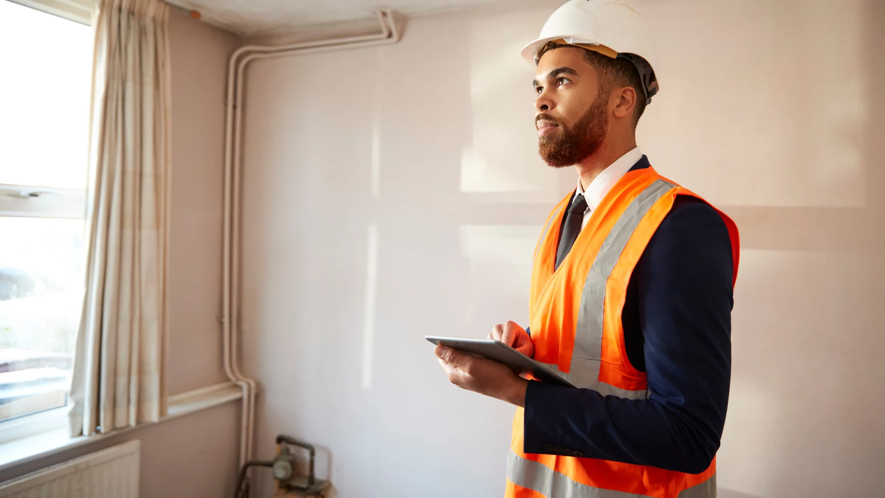 Surveyor inspecting a home interior with a tablet